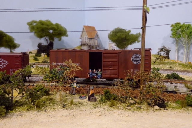 The hobos set up camp near an unused boxcar.